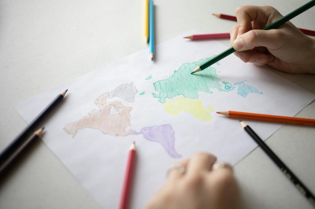 unrecognizable person drawing map with pencils