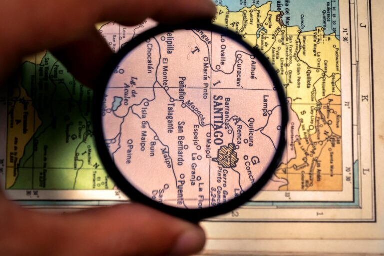 hand holding magnifying glass over map